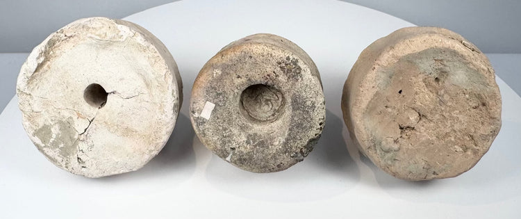Bottom view of three Eastern Indian Buddhist terracotta votive stupas showing base cavities and impressed features