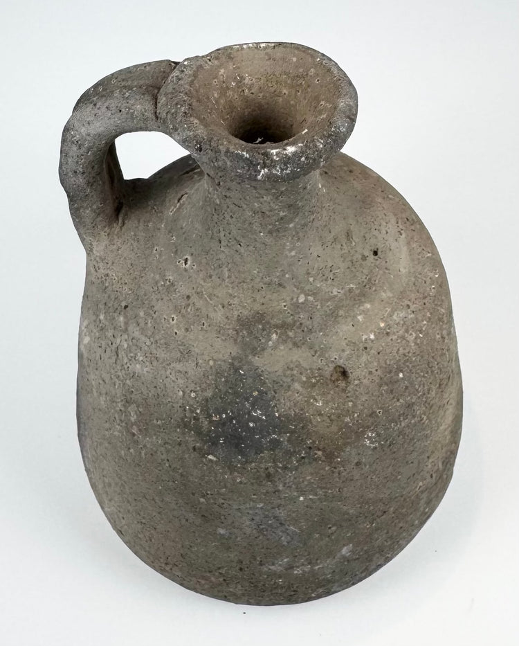 Ancient utilitarian pottery vessel with mineral inclusions and firing irregularities