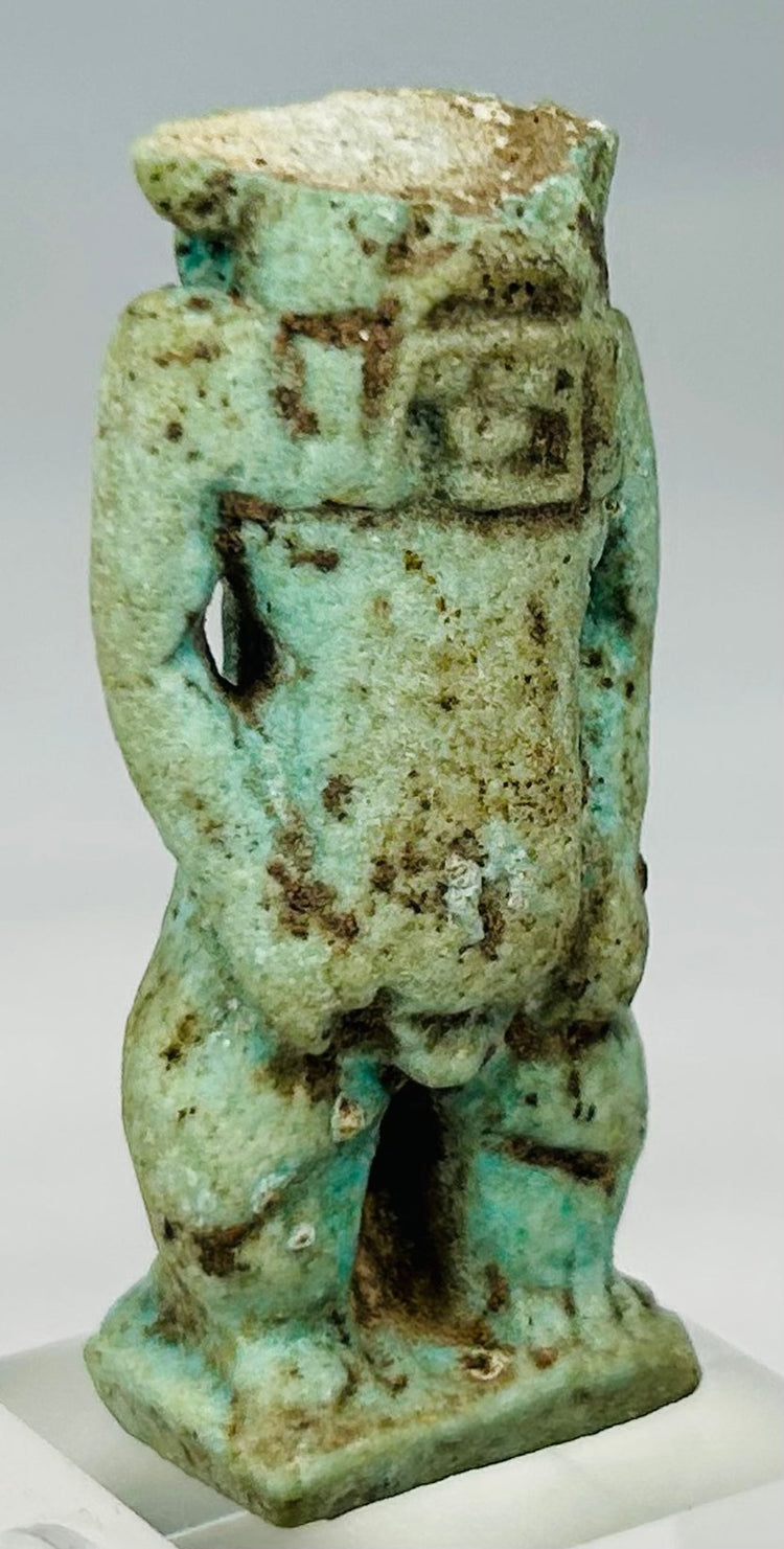 Three-quarter angled view of Egyptian Bes amulet showing preserved torso and stance