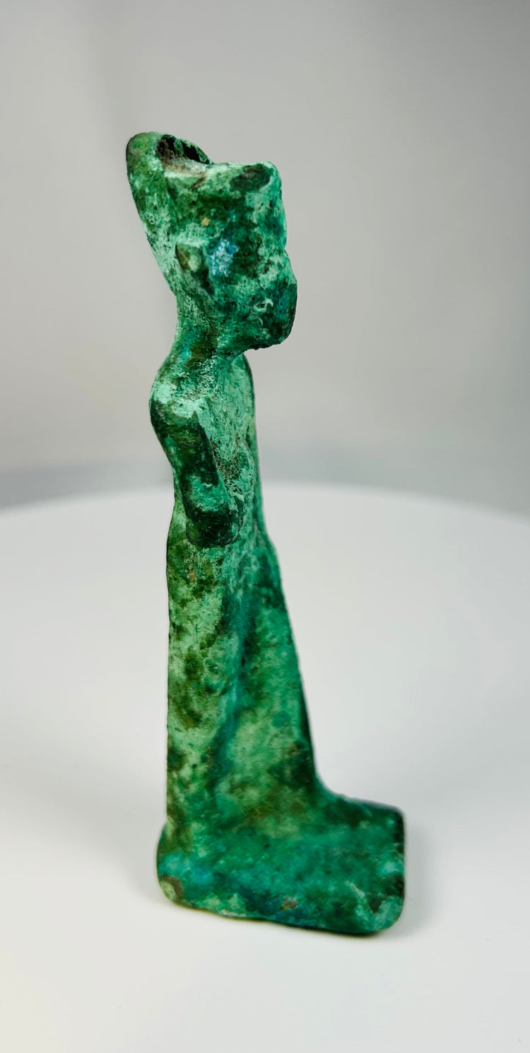 Ancient Egyptian bronze goddess statue showing classic frontal stance and simplified headdress.