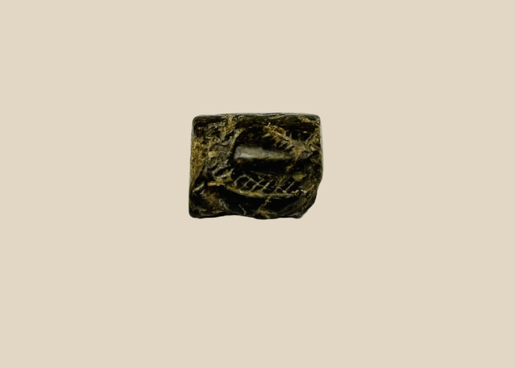 Ancient Egyptian snake-head amulet bead with carved serpentine motifs and central perforation