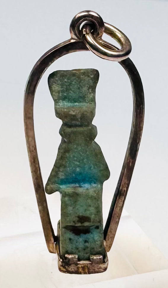 Side view of an Egyptian faience amulet showing its original suspension perforation