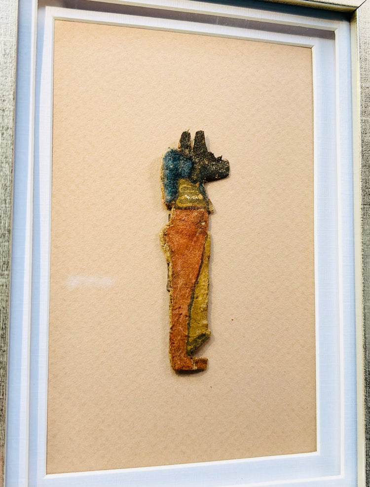 Ancient Egyptian funerary fragment showing Anubis in profile with painted details