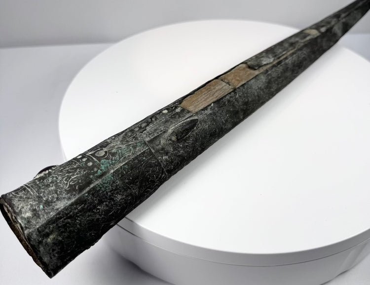 Wooden scabbard liner with two irregular openings separated by a central section of wood.