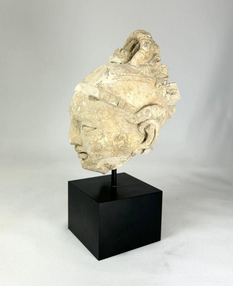12th–13th century Southeast Asian stucco Buddha head fragment, serene facial features, partial halo, black display base