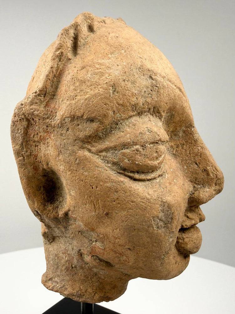 Gupta period terracotta head fragment profile with heavy-lidded eyes on black stand