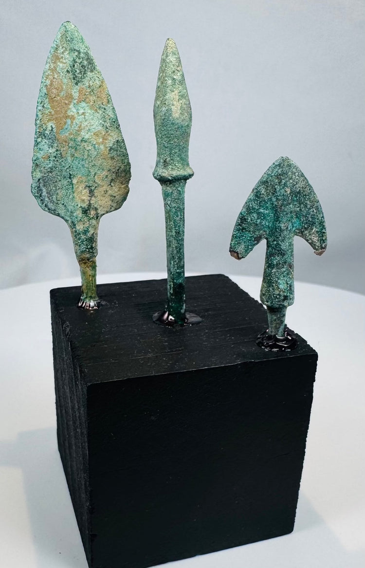 Mounted Bronze Age arrowhead group with green, blue-green, brown, and earthen deposits