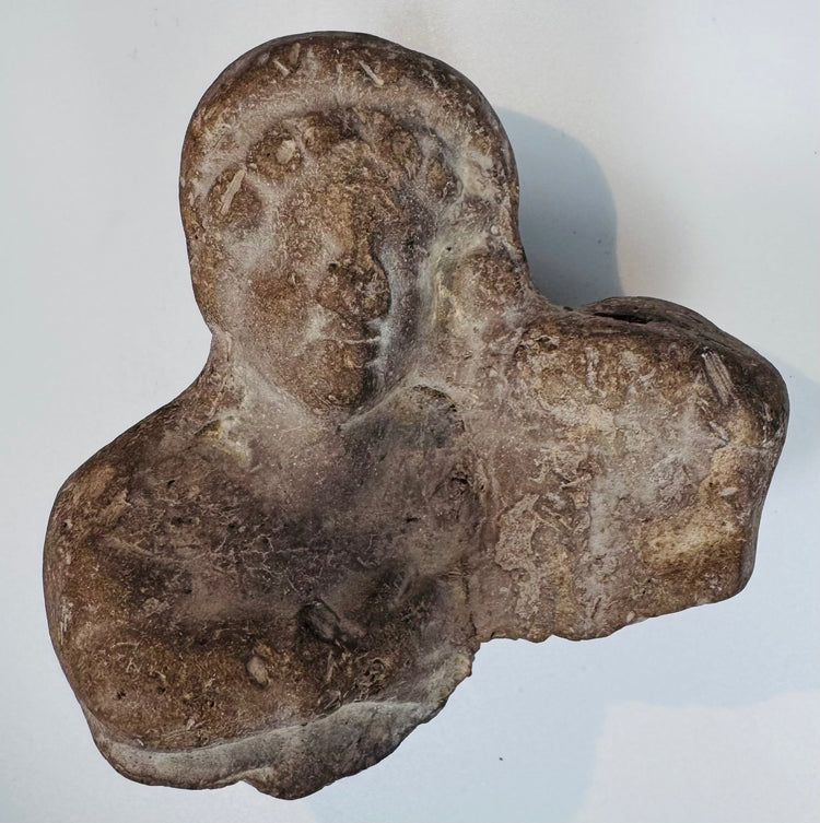 Authentic terracotta bust fragment with stylized facial features from the Classical Mediterranean world.