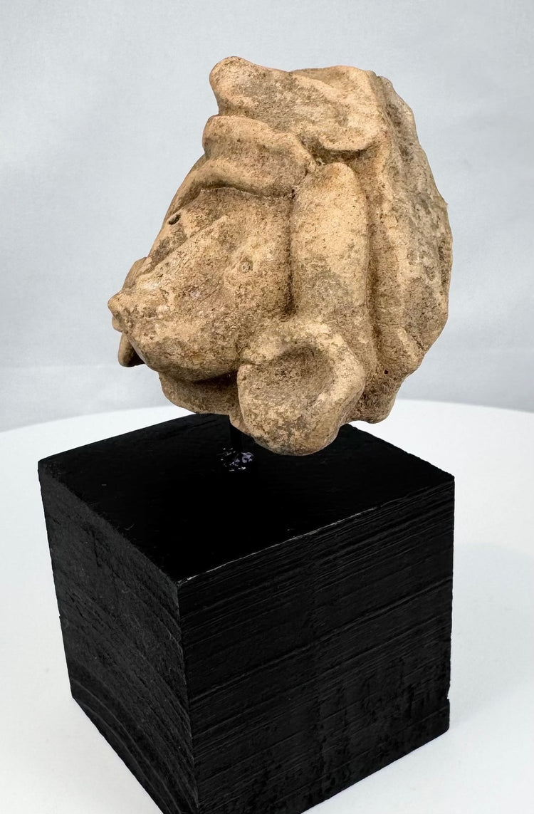 Weathered Pre-Columbian stone head with broad face and layered sculpted coiffure