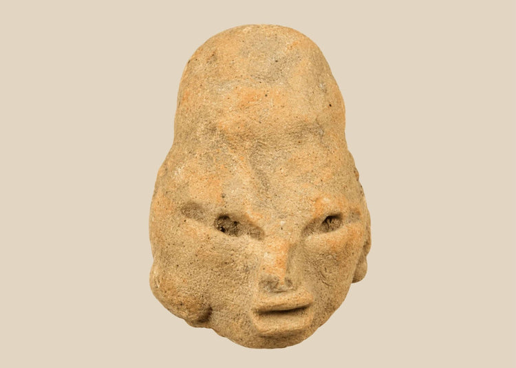 Small Pre-Columbian terracotta head fragment from West Mexico shaft-tomb culture, circa 300 BCE–300 CE, with almond-shaped eyes, defined features, and elongated cranial form, mounted on a black display base, photographed on a white background.
