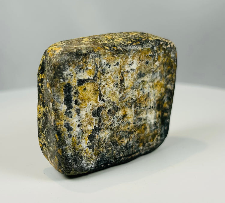 Mesopotamian style stone artifact with worn grid pattern carving