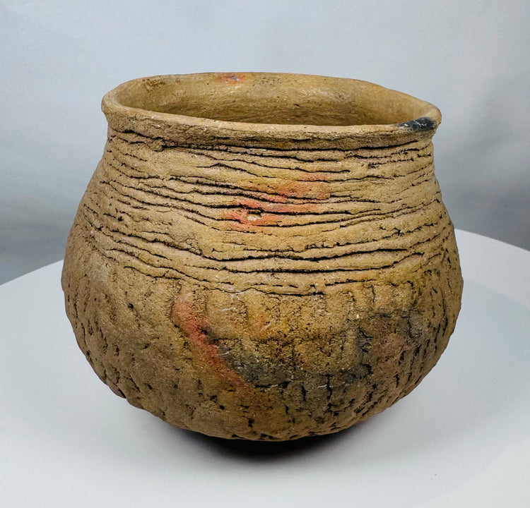 Pre-Columbian corrugated pottery jar attributed to the Casas Grandes culture, showcasing traditional utilitarian ceramic techniques and age-related wear.