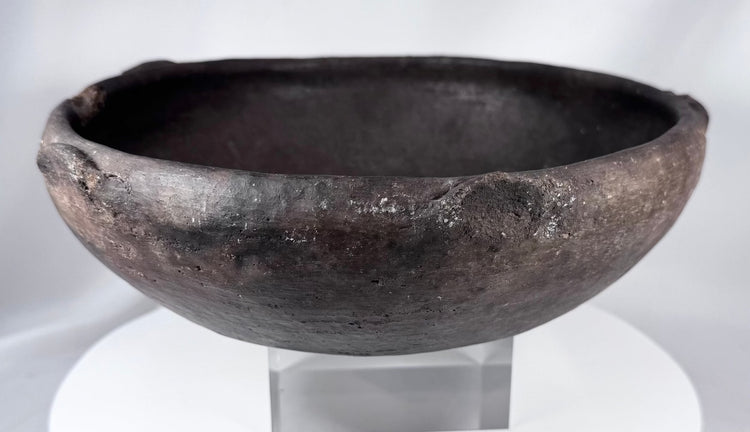 Hand-formed ancient pottery bowl with rim projections and mineralized archaeological surface