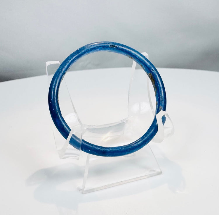 Ancient Roman glass bracelet crafted from vibrant cobalt-blue glass and preserved in complete condition.