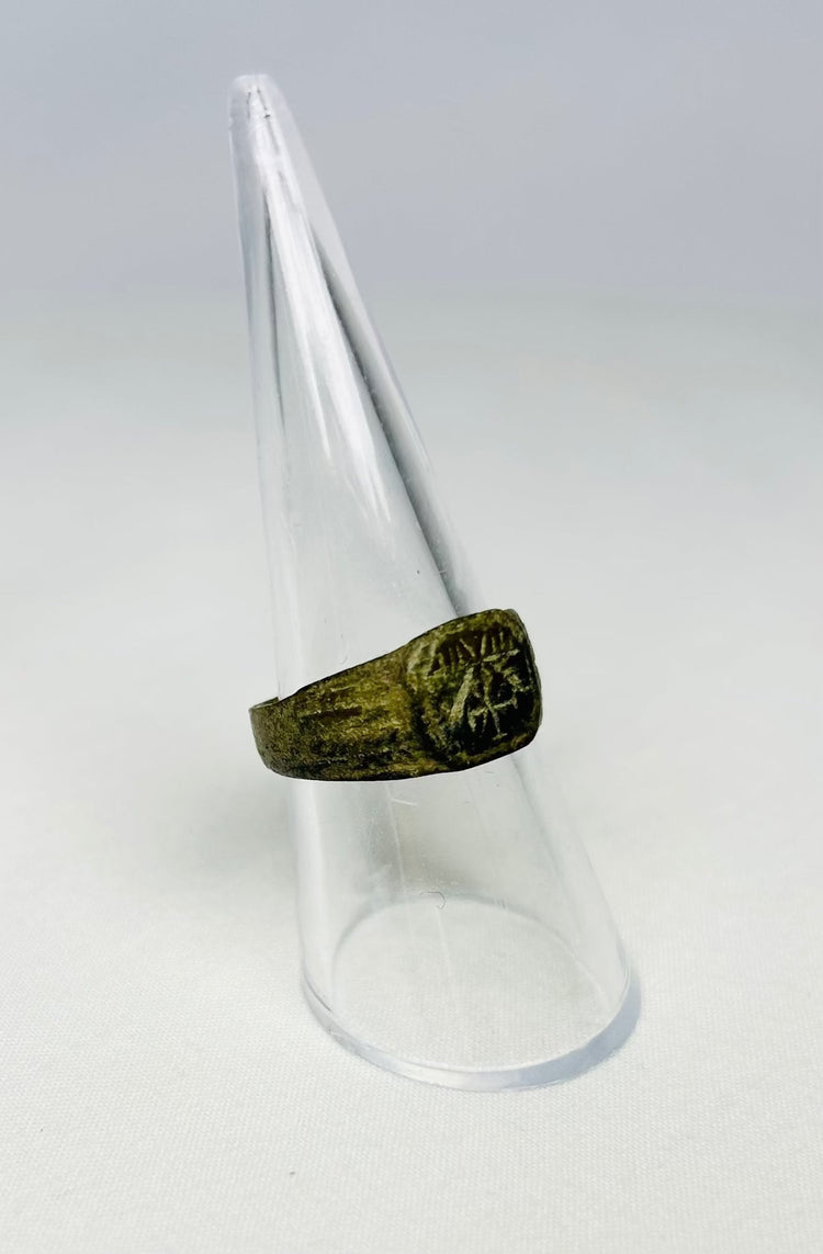 Angled view of ancient Roman bronze ring with dark patina, Chi-Rho engraving, early Christian era artifact, 1st–4th Century CE.