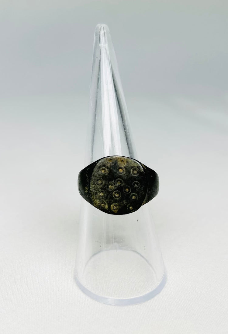 Detailed view of ring-and-dot decoration on a 1st–3rd century Roman bronze ring