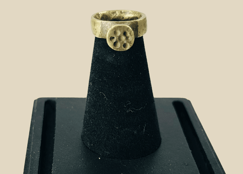 Front view of ancient Roman bronze ring showing circular rosette bezel with natural green patina.