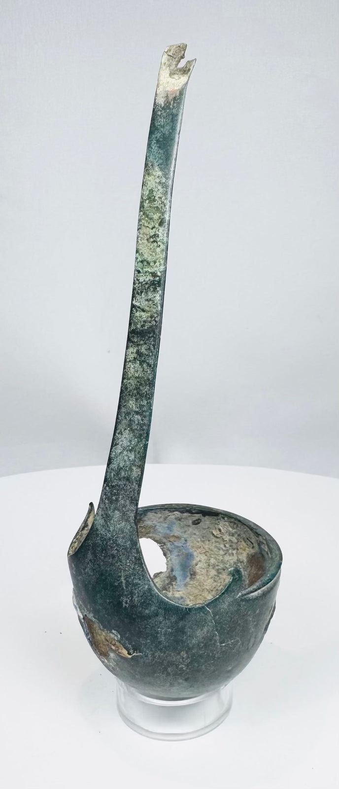 Close-up of Roman ladle bowl with corrosion, perforations, and mineral deposits