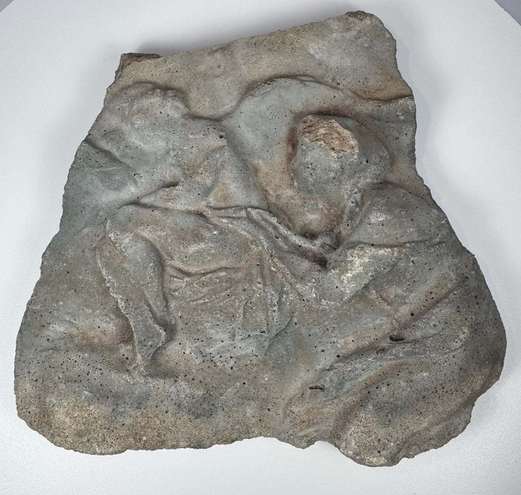 Roman volcanic tuff fragment with raised figural carving, irregular ancient-style edges and aged surface deposits