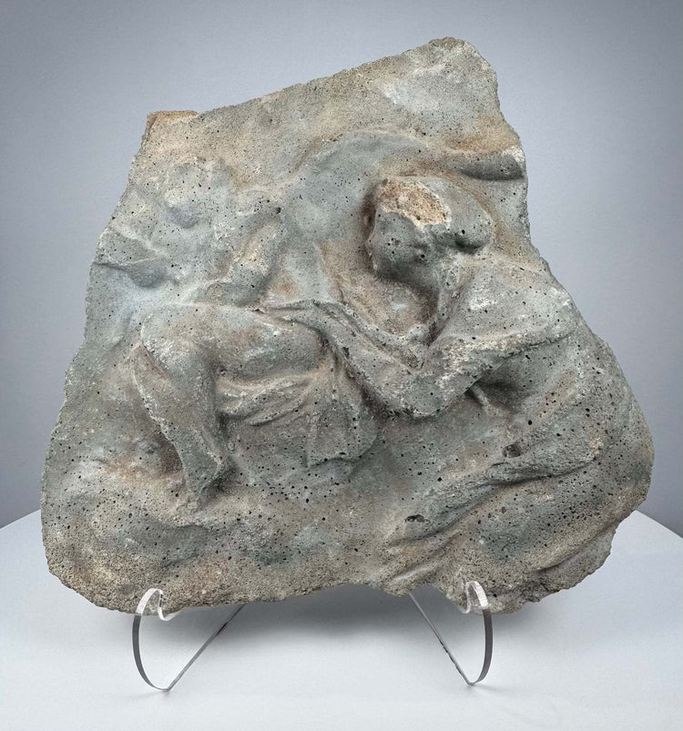 Ancient Roman carved stone relief depicting two Classical figures in deeply weathered volcanic tuff