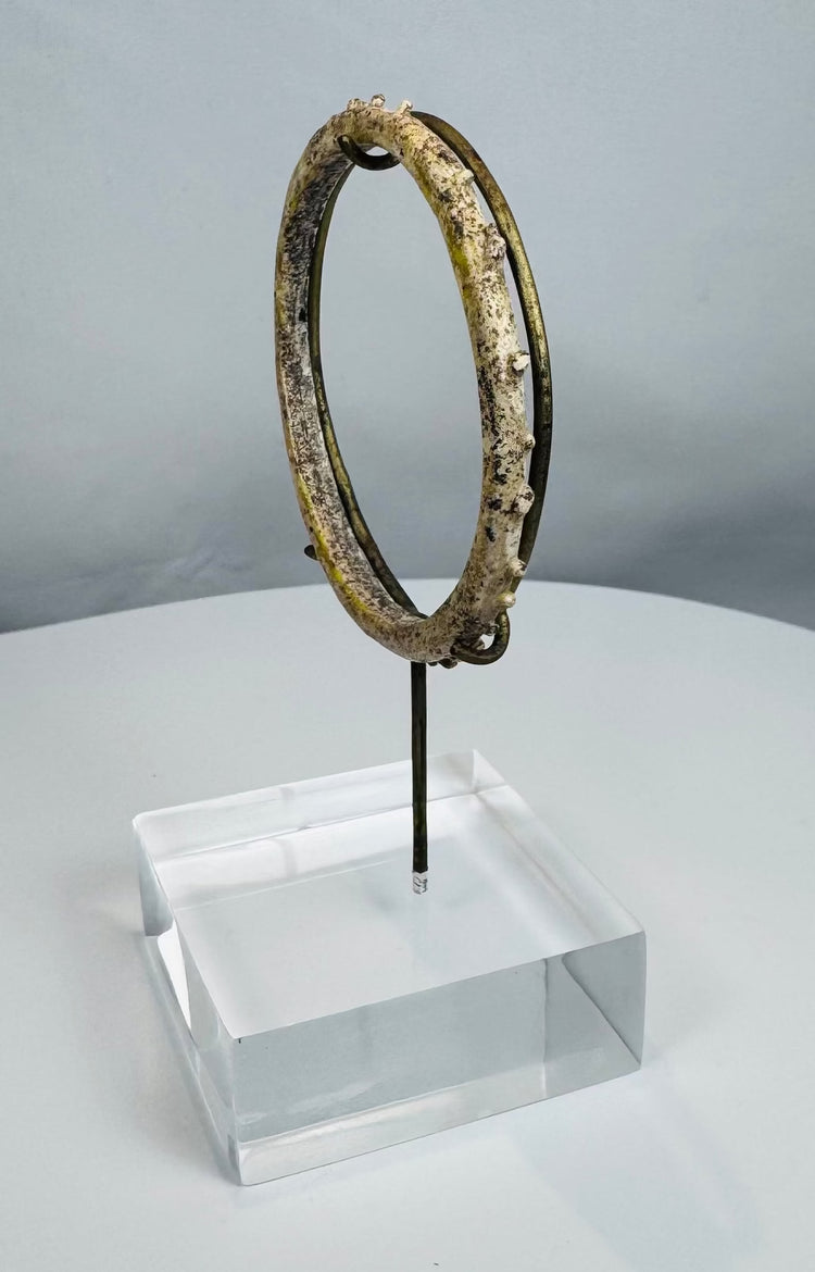 Historic Roman glass jewelry artifact with raised decorative elements and complete form.