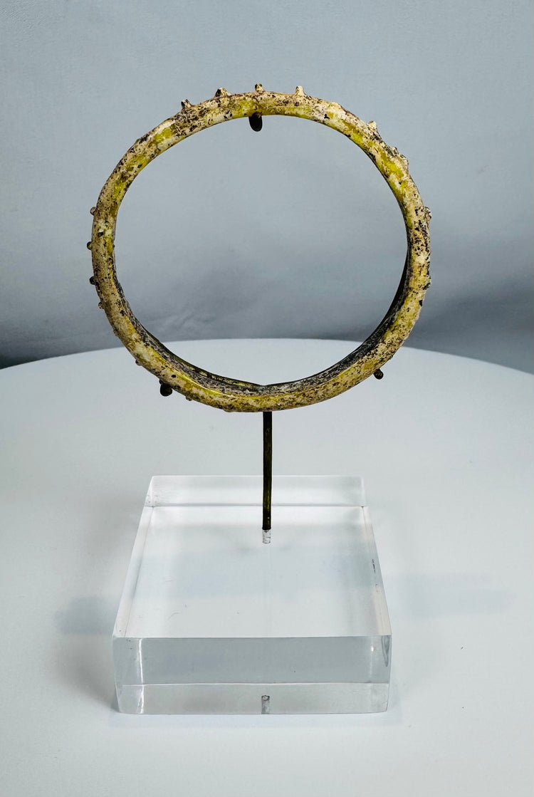 Ancient Roman blue-green glass bracelet with applied decorative protrusions and iridescent weathering.