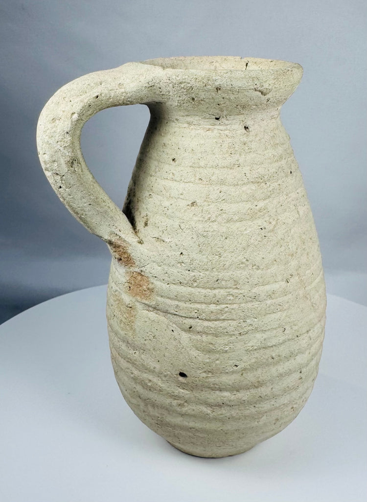 Roman North African pottery pitcher displaying mineral deposits, weathering, and ancient earthenware surfaces.