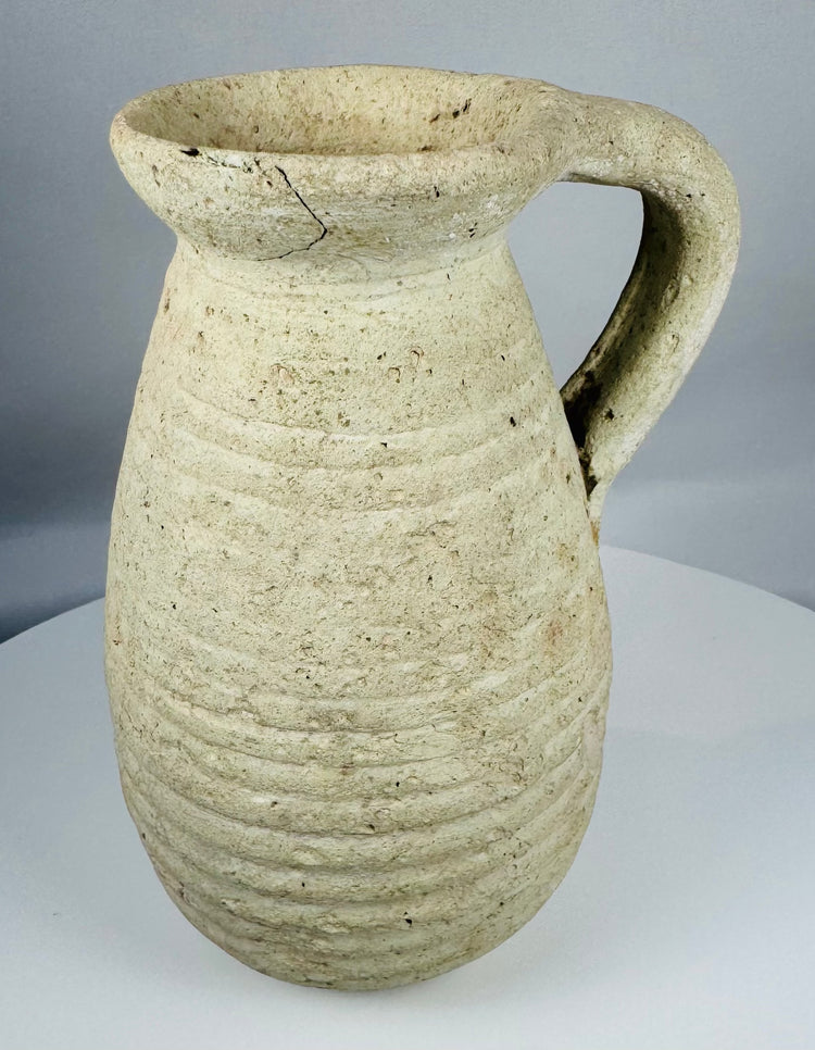 Authentic Roman North African earthenware pitcher with horizontal ribbed decoration and archaeological patina.