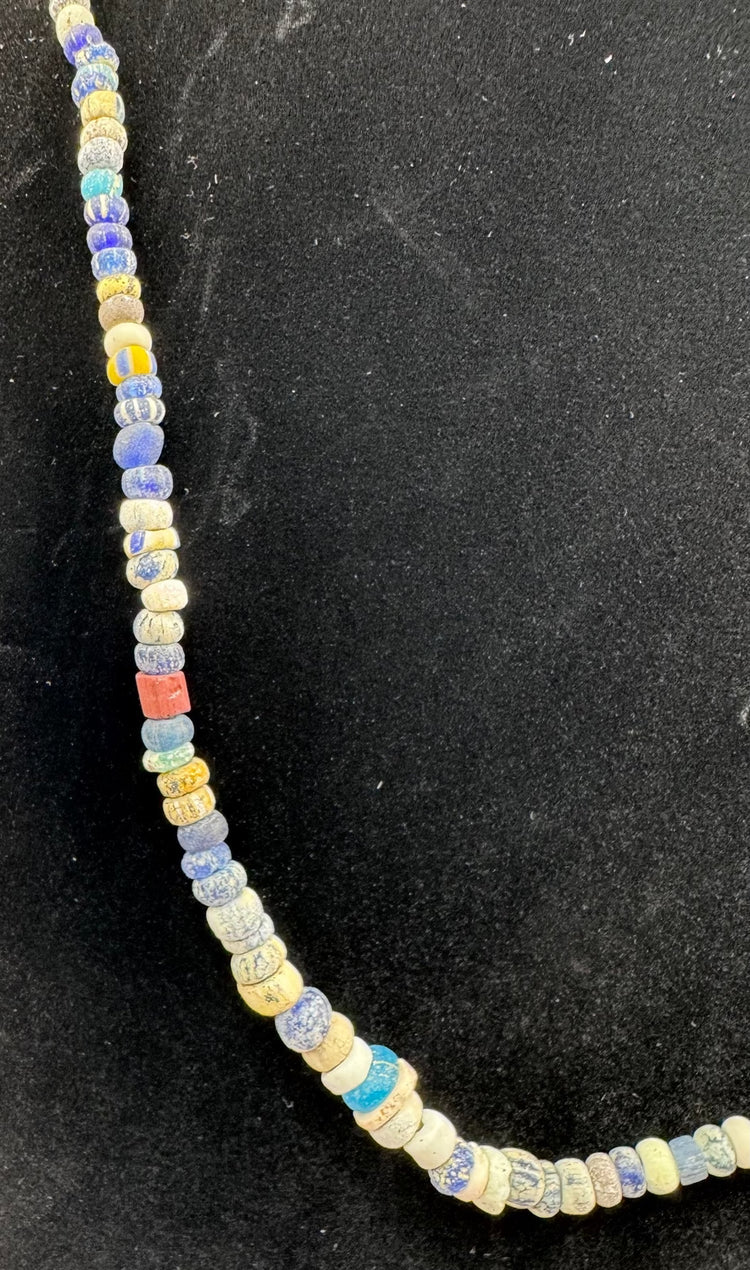Roman Imperial glass beads displaying striped decoration and surface iridescence
