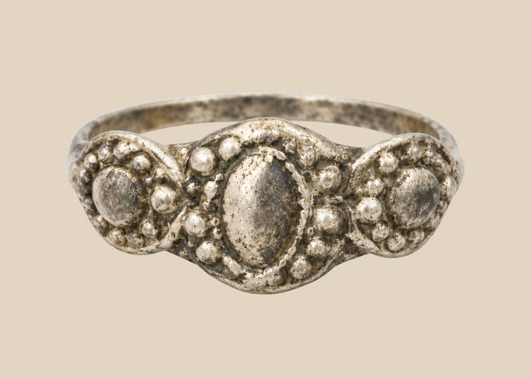 Ancient Late Roman–Byzantine silver ring featuring a clustered bezel of three oval motifs with natural aged patina, circa 300–600 CE.