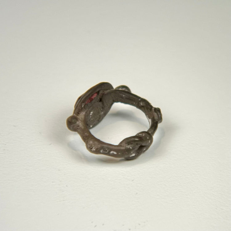 Side angle of Late Roman to Early Byzantine silver ring showing the raised garnet intaglio setting and band
