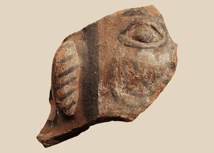 Ancient terracotta figural fragment with stylized eye and painted ear ornament, possibly Mesoamerican, circa 200 BCE–900 CE