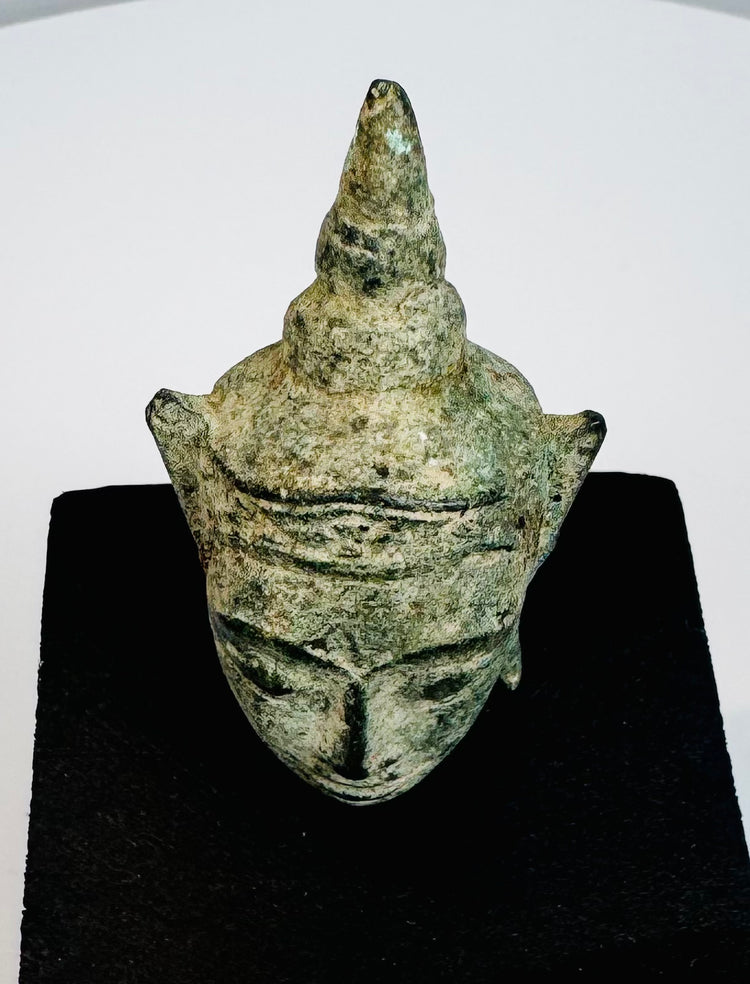 Early Southeast Asian Buddhist devotional sculpture with serene Buddha face and aged green bronze surface