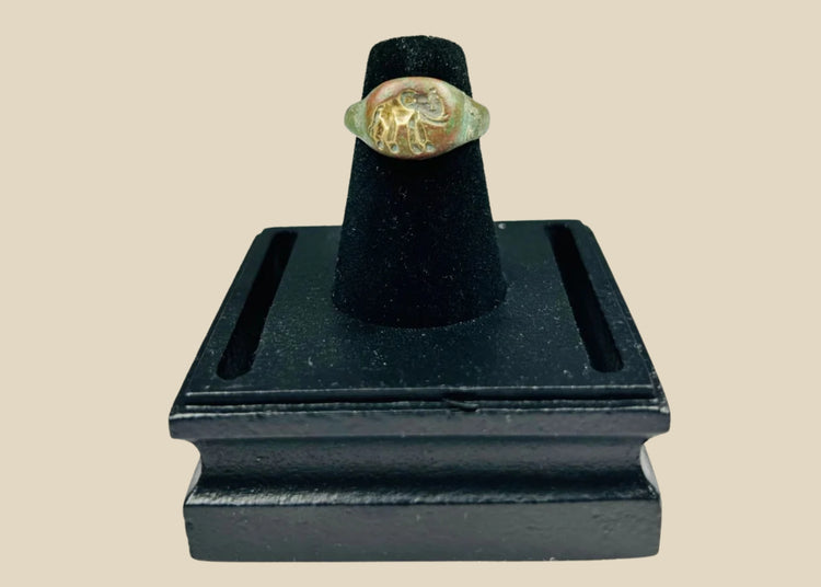 Ancient bronze ring with a finely engraved elephant motif on the bezel, green patina from age, symbolizing wisdom, power, and protection, circa 1st Millennium BCE.