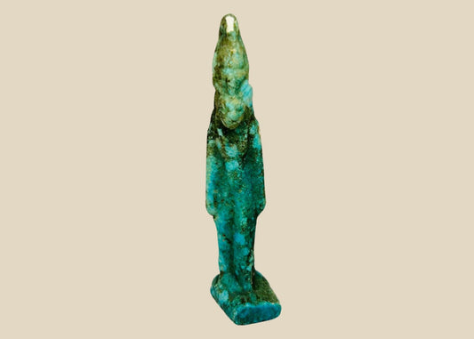 Ancient Egyptian turquoise faience amulet depicting Sekhmet, the lioness-headed warrior goddess, Late Period (664–332 BCE). Compact protective charm with finely modeled feline head, plain wig, and vibrant turquoise-to-green-blue glaze. Worn for divine protection, strength, and healing, reflecting Egyptian devotional artistry.