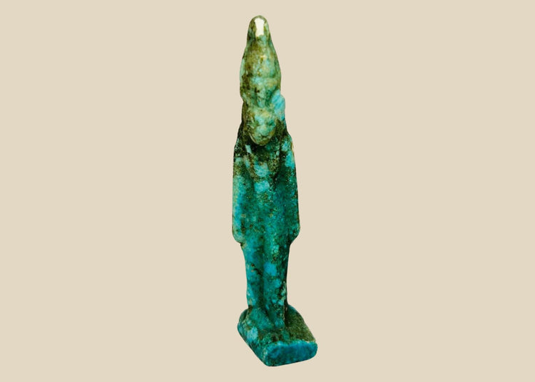 Ancient Egyptian turquoise faience amulet depicting Sekhmet, the lioness-headed warrior goddess, Late Period (664–332 BCE). Compact protective charm with finely modeled feline head, plain wig, and vibrant turquoise-to-green-blue glaze. Worn for divine protection, strength, and healing, reflecting Egyptian devotional artistry.
