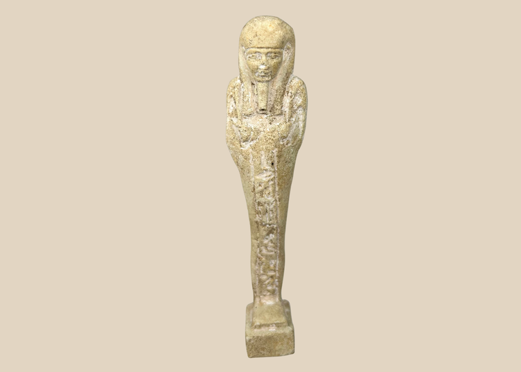 Ancient Egyptian limestone ushabti figurine standing upright on a white background
