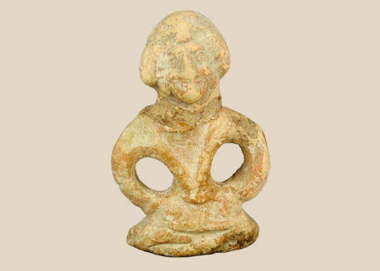 Mauryan terracotta figurine, circa 322–185 BCE, depicting a seated boy with arms bowed outward, traces of pigment, and natural aged patina.
