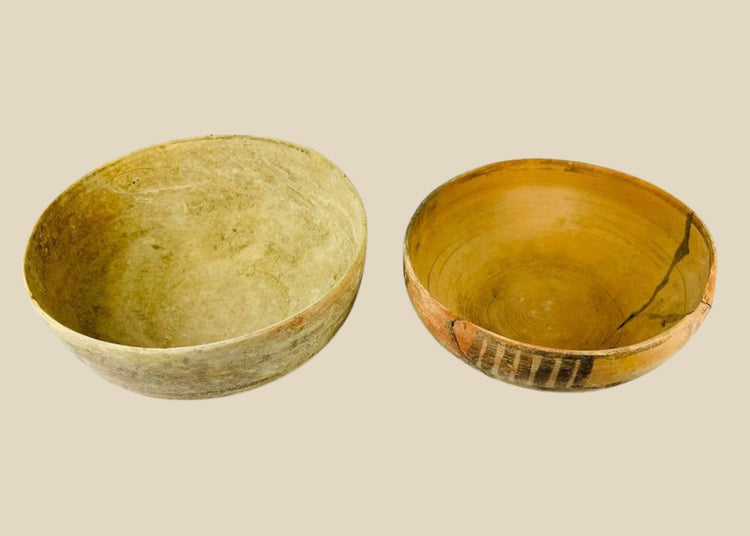 Two ancient Indus Valley terracotta bowls, circa 2nd–3rd millennium BCE; one plain with natural earthen patina, the other decorated with geometric polychrome painted motifs, both exhibiting age wear and archaeological restoration.