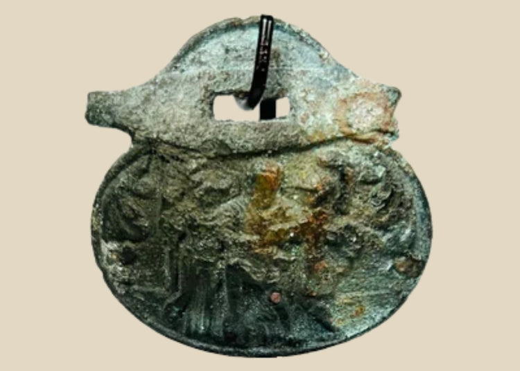 Ancient Roman bronze pendant, 1st–4th century CE, engraved with three standing figures including a helmeted figure, green patina, mounted on a custom stand.