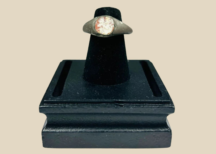 Ancient silver ring from the Mediterranean or Near East, 1st Millennium BCE, featuring a polished carnelian intaglio with traces of engraved motif. Smooth silver band with natural patina highlights the gemstone, reflecting its use as both a personal adornment and protective talisman in antiquity.