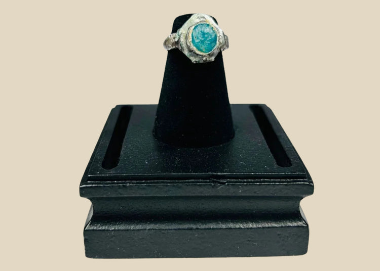 Ancient silver ring from the Near East or Mediterranean, 1st millennium BCE, featuring an engraved prancing horse with mounted rider and a raised turquoise bezel. Silver band with natural patina highlights fine ancient metalworking, symbolizing nobility, strength, and protective talismanic power.