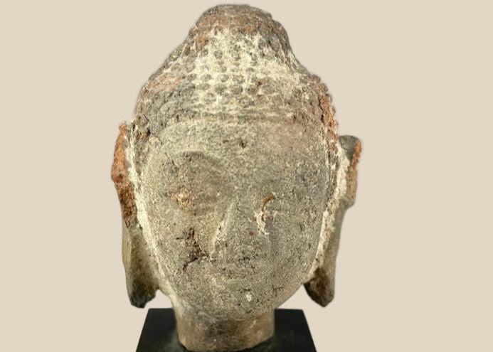 Ancient terracotta Buddha head from Southeast Asia, circa 5th–10th century CE, with serene facial features, weathered surface, and mounted display stand.