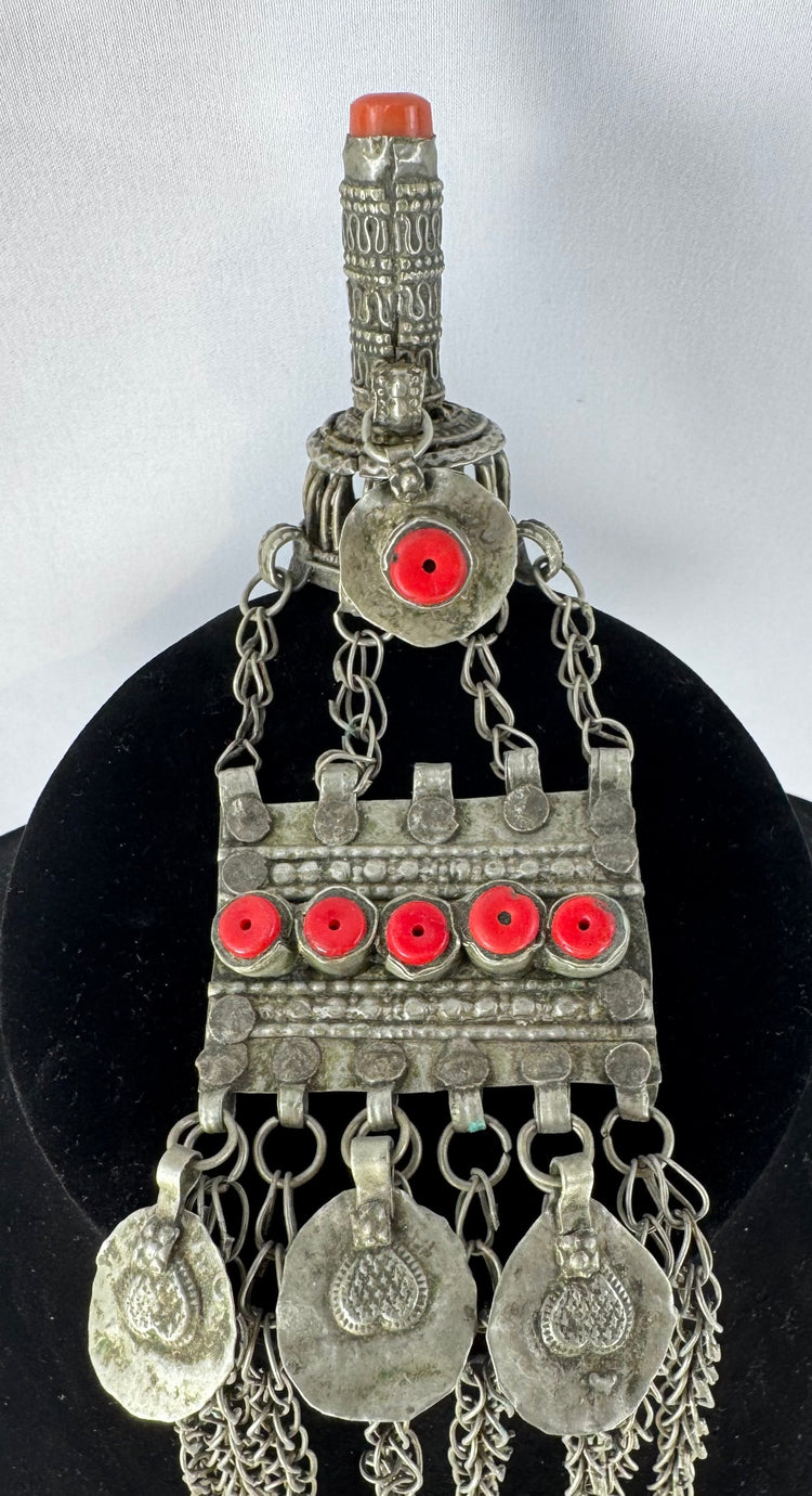 Antique Kuchi tribal ornament with a cylindrical prayer tube, decorative medallions, and long suspended chains.