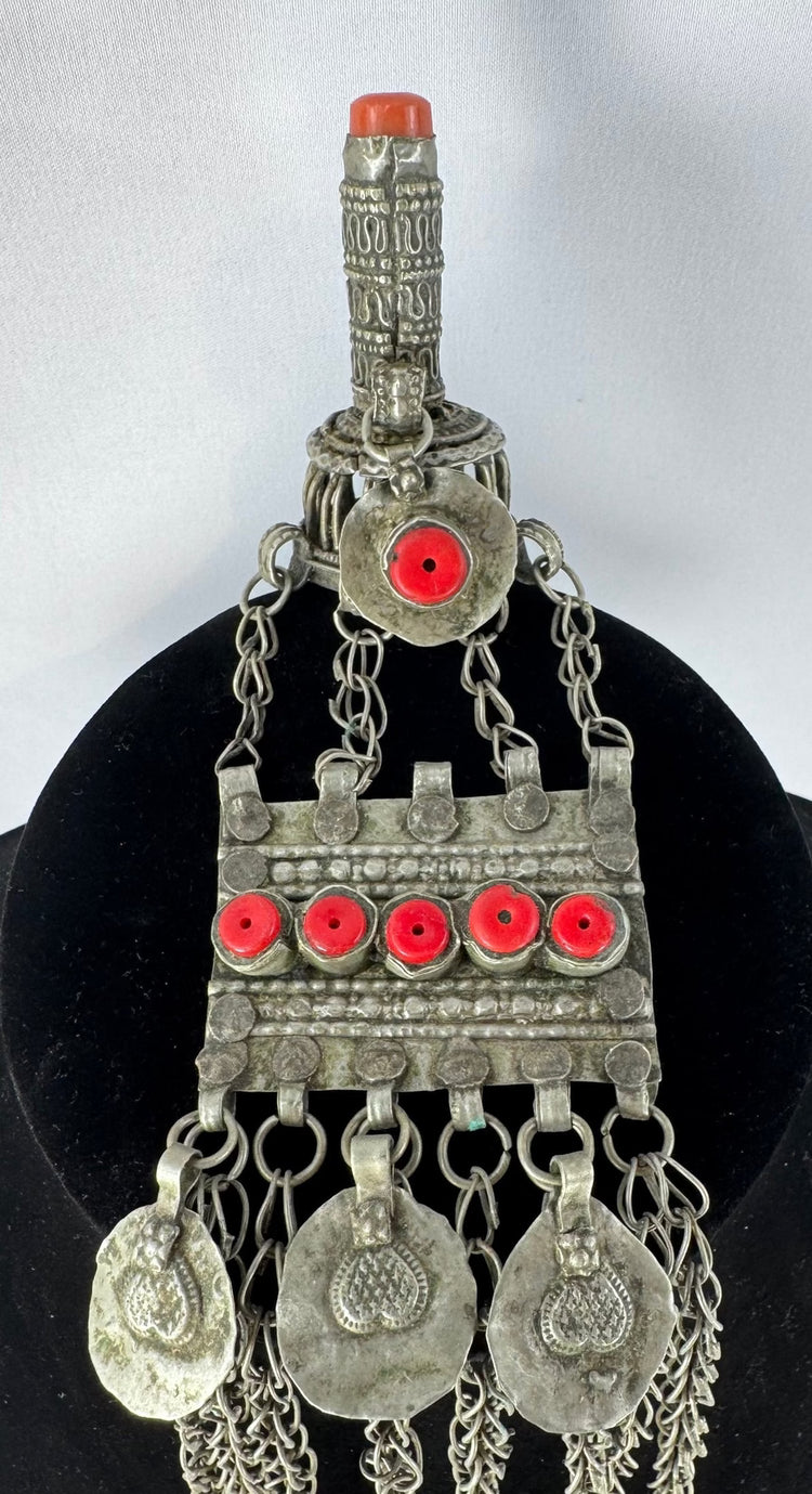 Antique Kuchi tribal ornament with a cylindrical prayer tube, decorative medallions, and long suspended chains.