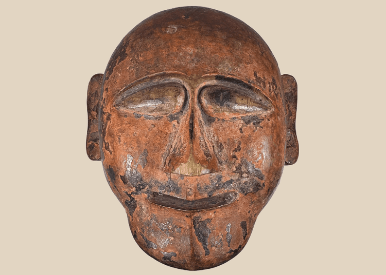 Hand-carved African tribal mask with stylized facial features and aged patina