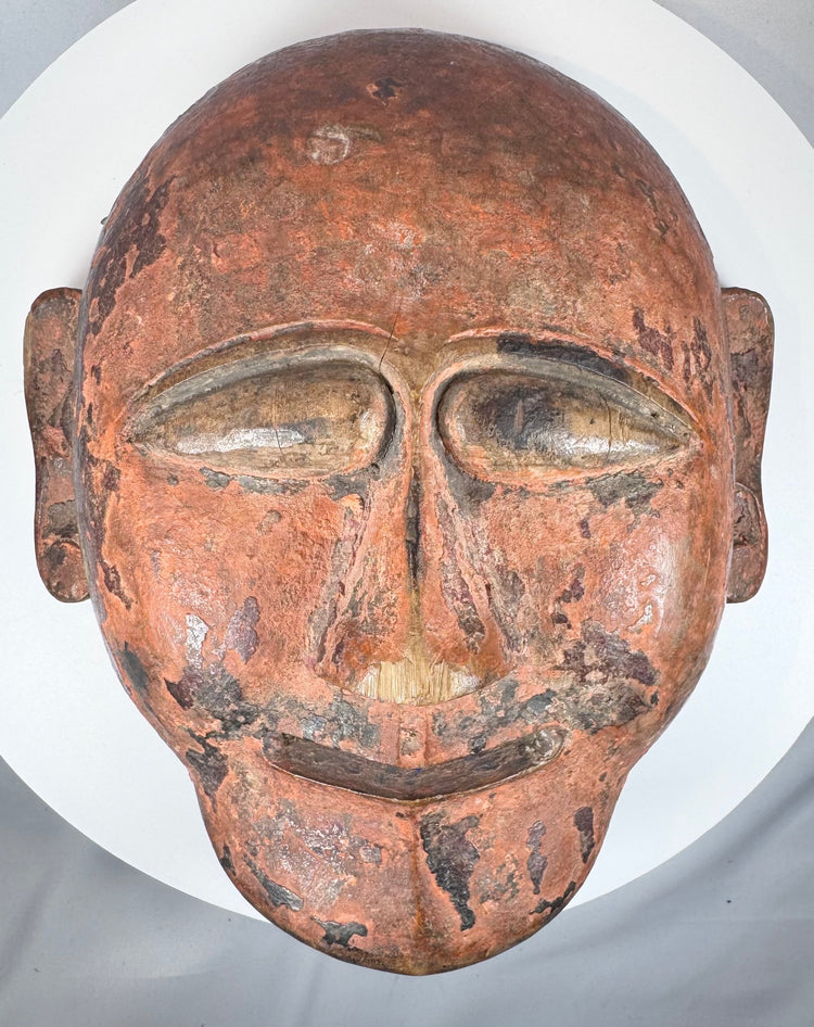 African ethnographic ceremonial mask with weathered surface, carved details, and ritual character