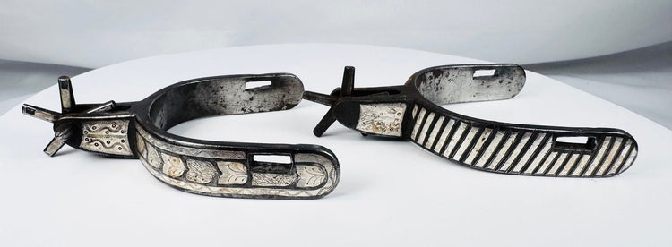 Early 20th-century American cowboy spurs with silver decoration and aged patina