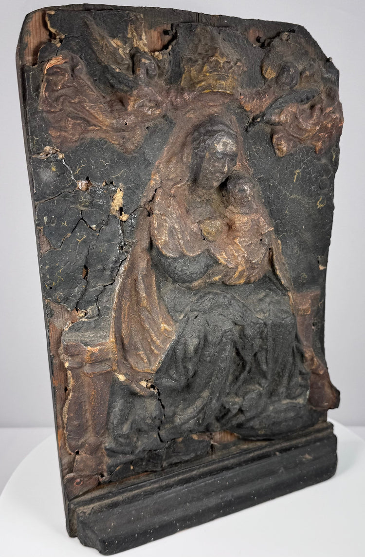 Hand-carved religious relief with deeply folded robes, recessed background and architectural framing elements