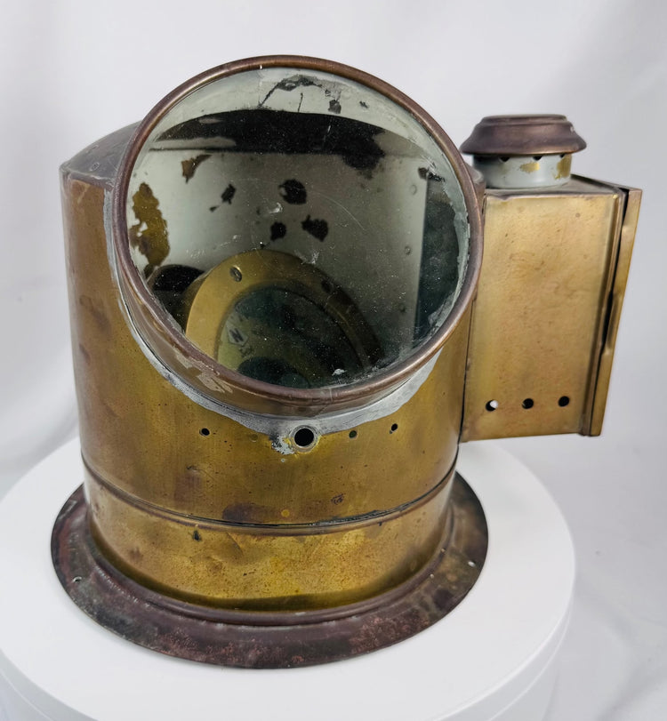 Antique shipboard navigational compass with aged brass patina and flanged mounting base